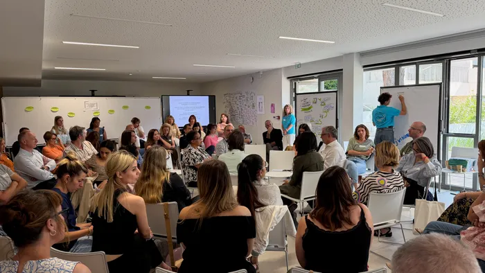 Atelier collectif en cercle, une participante trace au tableau